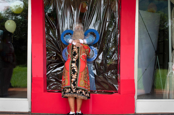 코로나19 대유행 속에 마리아 에르난데스가 11일(현지시간) 산살바도르의 호가르 자딘 드 로스 아부엘리토스 요양원에서 투명 커튼을 통해 이모를 껴안고 있다. 노인과 의사 루이스 버뮤즈에 따르면, 노인들이 코로나19에 감염될 위험 없이 친척들에게 포옹을 받을 수 있는 일종의 커튼을 사용하는 것은 우울증과 불안을 피하기 위한 조치라고 한다. AFP 연합뉴스