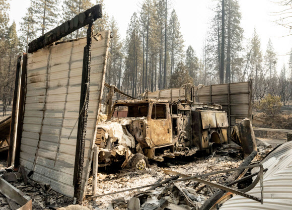 불에 탄 소방차가 14일(현지시간) 캘리포니아주 비법인 버트 카운티의 베리 크릭 지역에서 노스 복합 화재 중 타버린 잔해 안에 남겨져 있다. AFP 연합뉴스