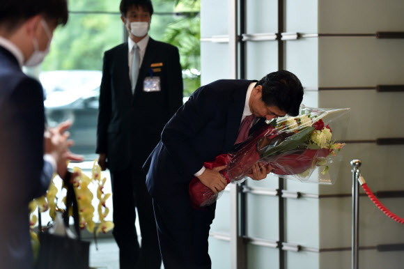 퇴임하는 아베 신조 일본 총리가 16일(현지시간) 마지막 국무회의를 마친 뒤 참모들에게 고개 숙여 인사하고 있다. AFP 연합뉴스