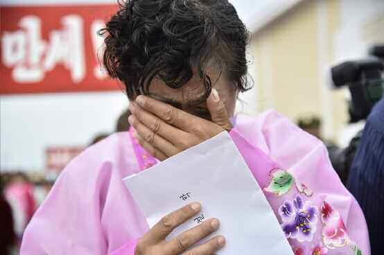 주택 이용 허가증 받아들고 눈물 흐리는 북한 주민