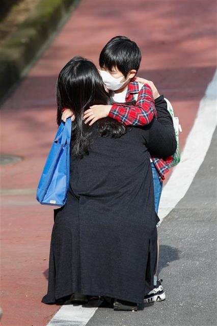 수도권 등교수업이 재개된 21일 오전 서울시내 초등학교에서 한 학생이 등교하기 전 어머니와 포옹하고 있다. 신종 코로나바이러스 감염증(코로나19) 재확산 여파로 전면 원격수업으로 전환된지 26일 만에 등굣길이 다시 열린 것이다. 이날 등교수업을 재개하는 수도권 학교는 서울 2000여개교, 인천 800여개교, 경기 4200여개교 등 7000여개교다. 2020.9.21 뉴스1