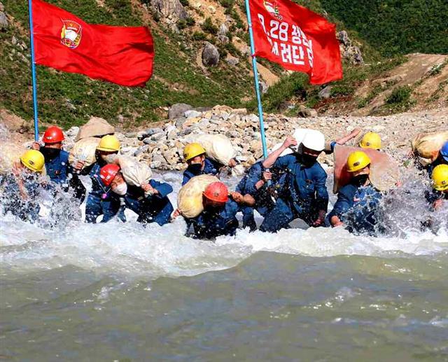 북한 노동당 기관지 노동신문은 21일 함경남도 검덕지구 일대의 수해 복구에 나선 8·28청년돌격대 제1여단의 성과를 조명했다. 신문은 “2400여㎥의 막돌 채취와 670여㎥의 버럭(광물 성분이 섞이지 않은 잡돌) 처리, 300여㎥의 혼석 운반과 140㎡의 석축을 진행하여 수십 리 구간의 파괴된 도로를 복구하고 여러 개의 임시 다리를 건설했다”라며 “피해복구에 동원된 인민군 군인들의 기동과 지역 인민들의 생활상 편의를 보장”했다고 여단 전투원들을 독려하고 나섰다. 평양 노동신문=뉴스1
