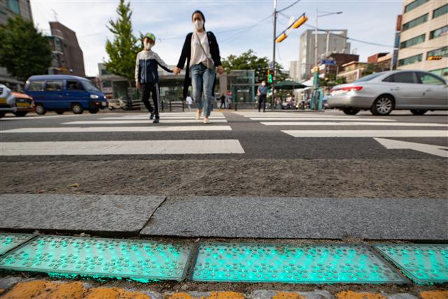 21일 오전 서울 중구 청구역 앞 스클존에 설치된 LED 바닥 신호등 앞으로 한 어린이가 등교하고 있다.  중구는 LED 바닥 신호등은 안전한 보행환경 조성을 위해 어린이보호구역 및 지하철역 횡단보도 19개소에 설치했다. 2020.9.21 뉴스1