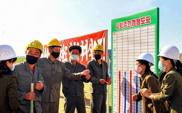 북한 노동당 기관지 노동신문은 함경도, 강원도 등 태풍 피해 복구 지역 곳곳에서 성과가 나고 있다고 24일 자평했다. 사진은 제2수도당원사단 대원들이 사회주의 경쟁 도표를 앞에 두고 대화하는 모습. 2020.9.24  노동신문 홈페이지 캡처