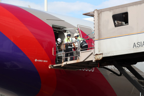 24일 오후 인천국제공항 1터미널에서 아시아나항공 관계자들이 A350 여객기에 화물을 탑재하고 있다. 아시아나항공은 2분기 실적 호조세를 이어가기 위해 A350-900 여객기 1대의 이코노미 좌석 283석을 화물탑재 공간으로 개조했다. 이번 개조로 5톤의 추가 화물을 적재해 편당 23톤의 화물 수송이 가능하다. 2020.9.24  연합뉴스