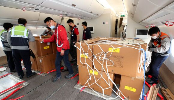24일 오후 인천국제공항 1터미널에서 아시아나항공 관계자들이 A350 여객기에 화물을 탑재하고 있다. 아시아나항공은 2분기 실적 호조세를 이어가기 위해 A350-900 여객기 1대의 이코노미 좌석 283석을 화물탑재 공간으로 개조했다. 이번 개조로 5톤의 추가 화물을 적재해 편당 23톤의 화물 수송이 가능하다. 2020.9.24  연합뉴스