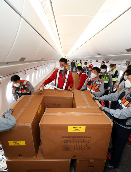 24일 오후 인천국제공항 1터미널에서 아시아나항공 관계자들이 A350 여객기에 화물을 탑재하고 있다. 아시아나항공은 2분기 실적 호조세를 이어가기 위해 A350-900 여객기 1대의 이코노미 좌석 283석을 화물탑재 공간으로 개조했다. 이번 개조로 5톤의 추가 화물을 적재해 편당 23톤의 화물 수송이 가능하다. 2020.9.24  연합뉴스