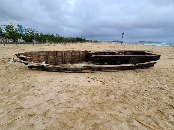 25일 오전 강원 고성군 삼포 해변에 북한 목선으로 추정되는 선박이 떠밀려 와 견인작업이 이뤄지고 있다. 군과 경찰 등은 태풍과 집중호우 때 북한에서 떠내려온 목선일 가능성이 큰 것으로 보고 대공 용의점이 없는 것으로 잠정 결론지었다. 2020.9.25 연합뉴스