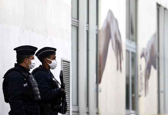 프랑스 경찰관들이 전날 흉기 테러가 발생한 파리 시내 샤를리 에브도 옛 사옥 앞에서 26일(현지시간) 경계 근무를 서고 있다. 파리 EPA 연합뉴스 