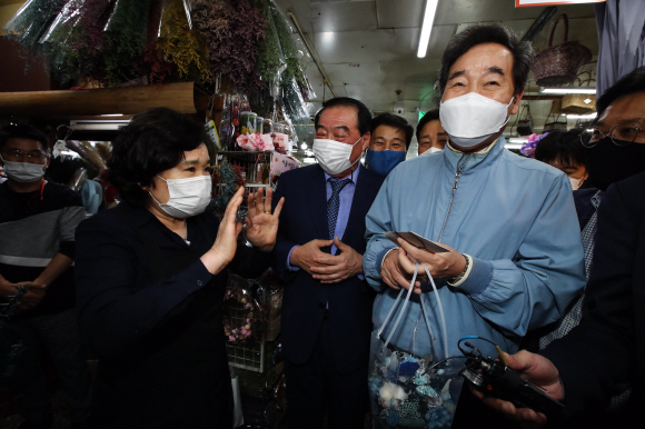 추석 연휴를 하루 앞둔 29일 서울 중구 남대문시장을 찾은 더불어민주당 이낙연 대표가 상인에게 꽃을 선물 받은뒤 환하게 웃고 있다.2020. 9. 29 김명국 선임기자 daunso@seoul.co.kr
