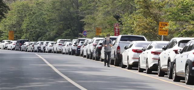 관광객 차량에 차도로 걷는 등산객