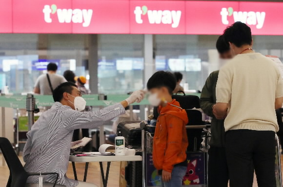 코로나19로 막혔던 인천~우한 노선 항공 운항이 재개된 지난달 16일 인천국제공항 제1터미널 출국장 티웨이항공 부스에서 중국 우한으로 출국하려는 시민들이 발열체크를 받고 있다. 뉴스1