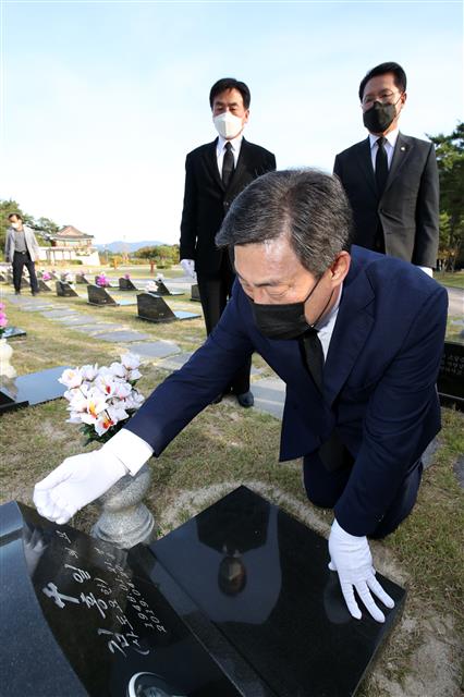 6일 오후 광주 북구 운정동 국립5·18민주묘지 2묘역에서 국민의힘 국민통합위원 김선동 의원이 정운천?윤영석 의원과 참배를 마친 뒤 김대중 전 대통령 장남인 김홍일 전 의원의 묘비를 어루만지고 있다.2020.10.6 뉴스1