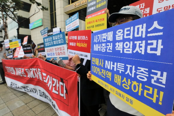 옵티머스 펀드 NH투자증권 피해자들이 지난 7월 23일 서울 여의도 NH투자증권 앞에서 ‘사기판매’를 규탄하고 있다. 뉴스1<br>