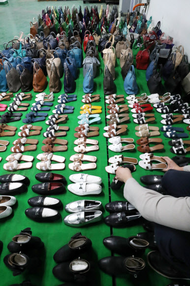 7일 오전 서울 강남구 서울본부세관에서 한 직원이 ‘특S급’ 짝퉁 압수품을 공개하고 있다. 서울본부세관은 고가 브랜드 위조품을 중국에서 직접 제작해 국내로 불법 유통한 남매 일당을 검거해 검찰에 넘겼다고 이날 밝혔다. 이 남매가 제작해 국내로 유통한 위조 가방, 신발, 장신구 등은 정품 시가로 따지면 290억원에 달했다. 2020.10.7  연합뉴스