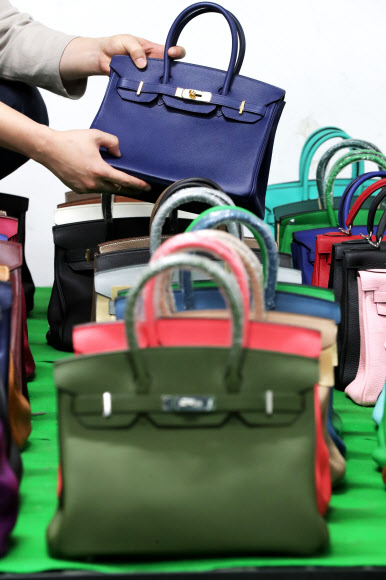 7일 오전 서울 강남구 서울본부세관에서 한 직원이 ‘특S급’ 짝퉁 압수품을 공개하고 있다. 서울본부세관은 고가 브랜드 위조품을 중국에서 직접 제작해 국내로 불법 유통한 남매 일당을 검거해 검찰에 넘겼다고 이날 밝혔다. 이 남매가 제작해 국내로 유통한 위조 가방, 신발, 장신구 등은 정품 시가로 따지면 290억원에 달했다. 2020.10.7  연합뉴스