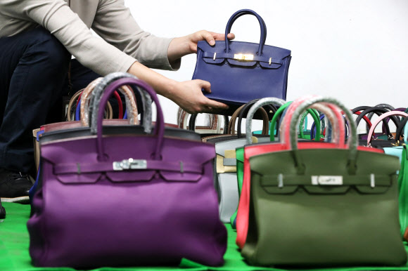 7일 오전 서울 강남구 서울본부세관에서 한 직원이 ‘특S급’ 짝퉁 압수품을 공개하고 있다. 서울본부세관은 고가 브랜드 위조품을 중국에서 직접 제작해 국내로 불법 유통한 남매 일당을 검거해 검찰에 넘겼다고 이날 밝혔다. 이 남매가 제작해 국내로 유통한 위조 가방, 신발, 장신구 등은 정품 시가로 따지면 290억원에 달했다. 2020.10.7  연합뉴스