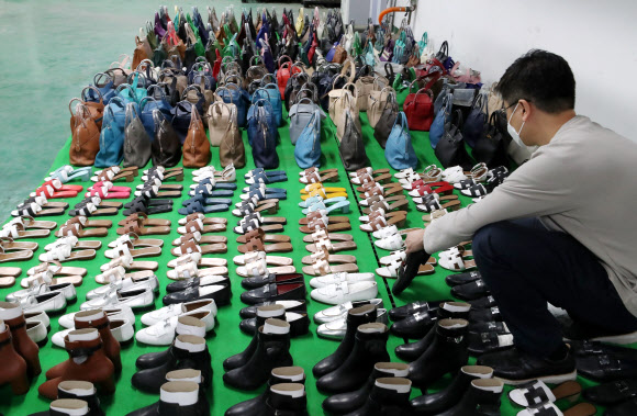 7일 오전 서울 강남구 서울본부세관에서 한 직원이 ‘특S급’ 짝퉁 압수품을 공개하고 있다. 서울본부세관은 고가 브랜드 위조품을 중국에서 직접 제작해 국내로 불법 유통한 남매 일당을 검거해 검찰에 넘겼다고 이날 밝혔다. 이 남매가 제작해 국내로 유통한 위조 가방, 신발, 장신구 등은 정품 시가로 따지면 290억원에 달했다. 2020.10.7  연합뉴스