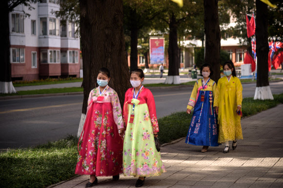 한복을 차려 입은 북한 여성들이 10일(현지시간) 평양에서 노동당 창건 75주년을 맞아 거리를 걷고 있다. AFP 연합뉴스