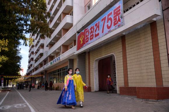 한복을 차려 입은 북한 여성들이 10일(현지시간) 평양에서 노동당 창건 75주년을 맞아 거리를 걷고 있다. AFP 연합뉴스