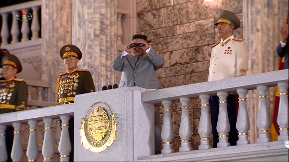 북한이 노동당 창건 75주년을 맞아 평양에서 열병식을 진행했다고 조선중앙TV가 10일 보도했다. 연설대 위에 선 김정은 위원장이 망원경을 들고 광장 아래쪽의 열병식을 내려다보고 있다. [조선중앙TV 화면]