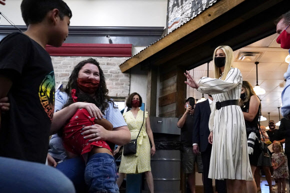 Ivanka Trump, right, daughter and adviser to President Donald Trump, waves to people as she tours American Way Antiques Sunday, Oct. 11, 2020, in Chandler, Ariz. (AP Photo/Ross D. Franklin)