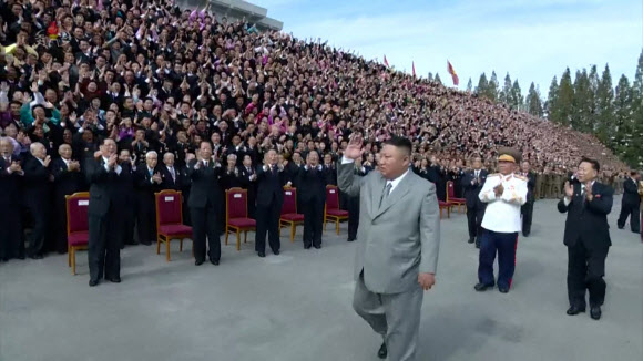 김정은 북한 국무위원장이 11일 노동당 창건 75주년 기념 열병식 참가자들에게 손을 들어 인사하고 있다. [조선중앙TV 화면] 2020.10.12 연합뉴스