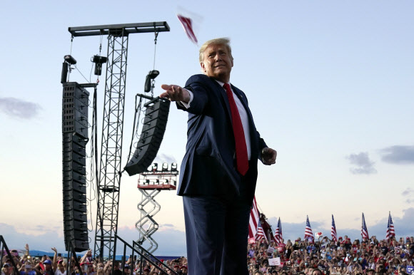 도널드 트럼프 대통령이 12일(현지시간) 미국 플로리다주 올랜도 샌포드 국제공항의 유세장에 도착해 쓰고 있던 마스크를 군중 속으로 던지고 있다. AP 연합뉴스