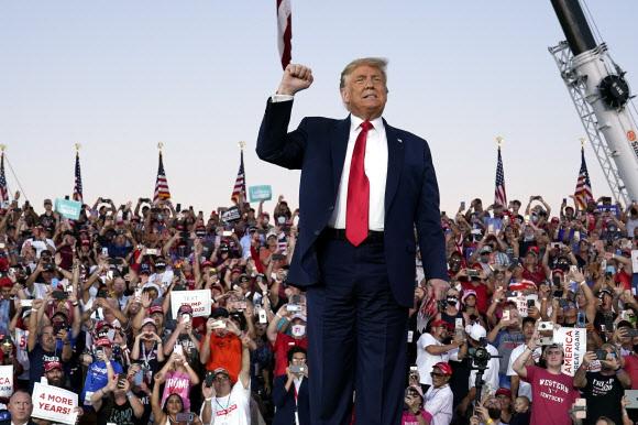 도널드 트럼프 대통령이 12일(현지시간) 미국 플로리다주 올랜도 샌포드 국제공항의 유세장에 도착해 주먹을 쥐고 들어 올리고 있다. AP 연합뉴스