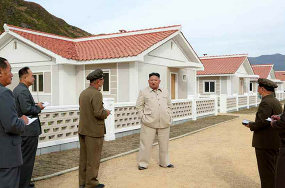 태풍 피해지역에 새로 지은 주택을 돌아보며 환히 웃는 김정은