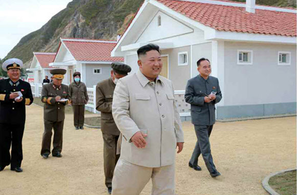 태풍 피해지역에 새로 지은 주택을 돌아보며 환히 웃는 김정은