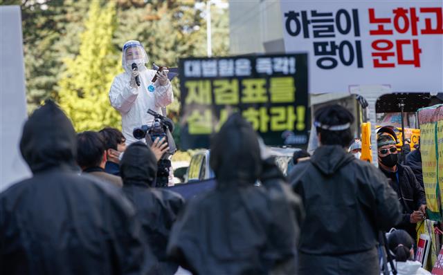 부동산악법저지 국민행동, 자유민주주의연합 등 회원들이 17일 오후 서울 여의도 더불어민주당 당사 앞에서 방호복을 입고 정부 부동산 정책 반대·6.17 부동산대책 철회 촉구 집회를 열고 있다. 2020.10.17 뉴스1