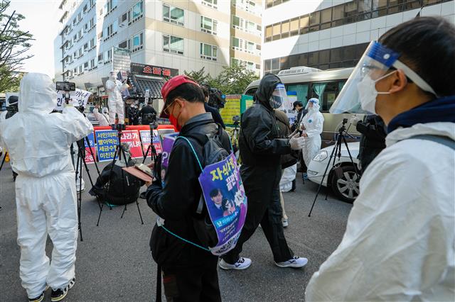 부동산악법저지 국민행동, 자유민주주의연합 등 회원들이 17일 오후 서울 여의도 더불어민주당 당사 앞에서 방호복을 입고 정부 부동산 정책 반대·6.17 부동산대책 철회 촉구 집회를 열고 있다. 2020.10.17 뉴스1