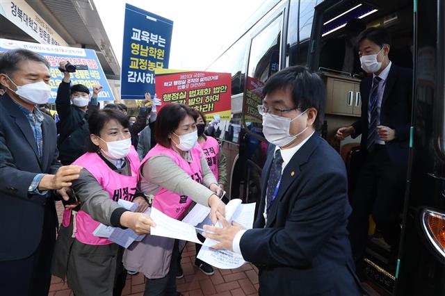 19일 오전 대구 북구 경북대학교 대구캠퍼스 글로벌플라자에서 열리는 국회 교육위원회의 대구·경북 및 강원 국립대 및 광역교육청에 대한 국정감사를 앞두고 국감장 앞에서 실험실 폭발사고 피해학생 치료비 미지급 경북대에 대한 엄중한 국정감사 촉구하는 대학구성원과 영남학원이 총장선출 규정 개정을 부결시킨 것과 관련해 교정 농단을 규탄하는 영남대 교수회 등이 버스에서 내리는 대학 관계자를 향해 선전전을 펼치고 있다. 2020.10.19 뉴스1