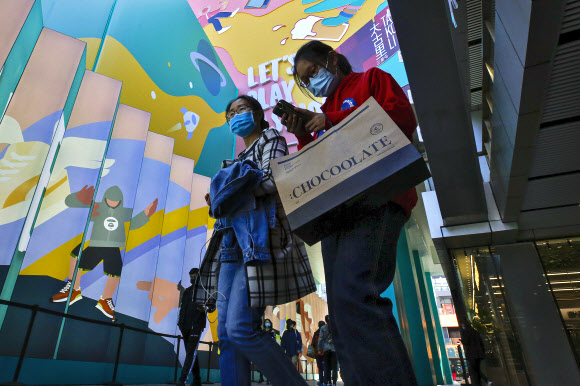 마스크를 쓴 중국인들이 19일 수도 베이징의 한 유명 쇼핑몰을 드나들고 있다. 중국 국가통계국은 이날 3분기 국내총생산이 지난해 같은 기간보다 4.9% 증가했다고 밝혔다. 베이징 AP 연합뉴스