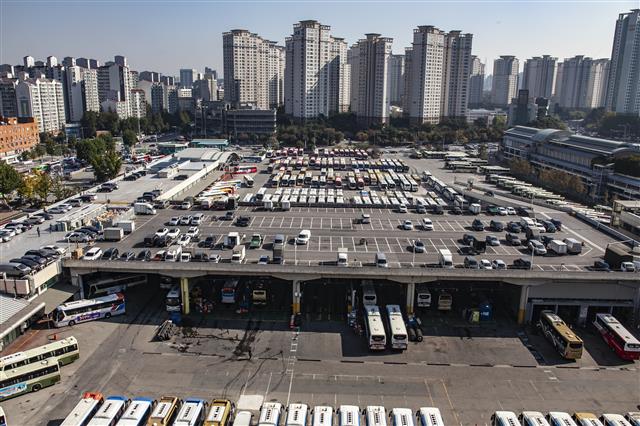 서울고속버스터미널 10층 옥상 하늘공원에서 내려다본 서울 강남 아파트 숲과 주차장. 발아래 도착지별로 고속버스들이 줄지어 있다.