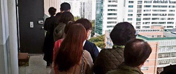 지난 13일 서울 강서구 가양동의 한 아파트 문 앞에 전세매물이 나왔다는 소식을 들은 예비 세입자 십여명이 집을 보기 위해 줄을 서서 기다리고 있다. 온라인커뮤니티 캡처