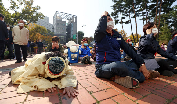 20일 오후 서울 마포구청 앞에서 서부지역노점상연합회 주최로 열린 ‘코로나 재난시기 노점상만 단속하는 마포구청 규탄대회’에서 한 참가자가 동료 상인의 삭발식을 보며 오열하고 있다. 2020.10.20  연합뉴스