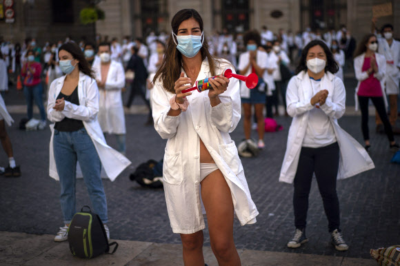 근무 조건에 항의하기 위해 옷을 벗은 전공의들이 20일(현지시간) 스페인 바르셀로나에서 파업 중 시위에 참가하고 있다. AP 연합뉴스