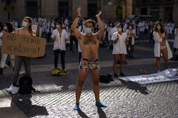 근무 조건에 항의하기 위해 옷을 벗은 전공의들이 20일(현지시간) 스페인 바르셀로나에서 파업 중 시위에 참가하고 있다. AP 연합뉴스