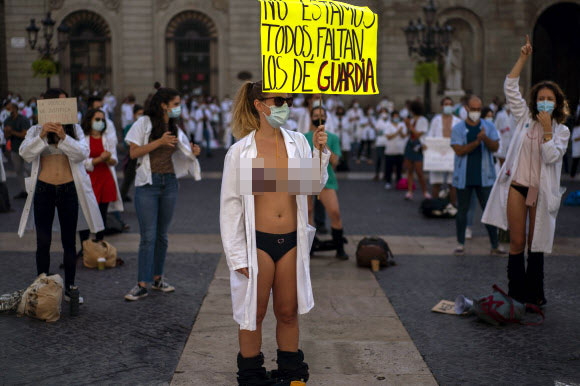 근무 조건에 항의하기 위해 옷을 벗은 전공의들이 20일(현지시간) 스페인 바르셀로나에서 파업 중 시위에 참가하고 있다. AP 연합뉴스