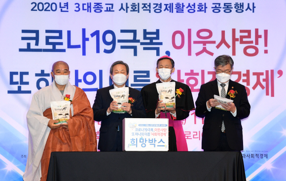 이재갑 고용노동부 장관과 3대 종교 지도자들이 22일 서울 종로구한국교회100주년기념관에서 열린 사회적 경제 활성화를 다짐하는 3대 종교 공동행사에서 쌀과 생필품 등을 취약계층에 전하는 ‘희망박스’에 담고 있다.  왼쪽부터 성공스님, 신정호 목사, 유경촌 주교, 이재갑 장관.  2020.10.22 정연호 기자 tpgod@seoul.co.kr