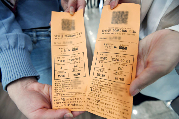 제주항공 ‘인천 to 인천’ 관광비행 승객이 23일 인천국제공항 1터미널에서 발권한 항공권을 들어 보이고 있다. 이날 제주항공은 일반인을 대상으로 국내 상공을 선회한 뒤 복귀하는 관광비행을 진행했다. 2020.10.23  공항사진기자단