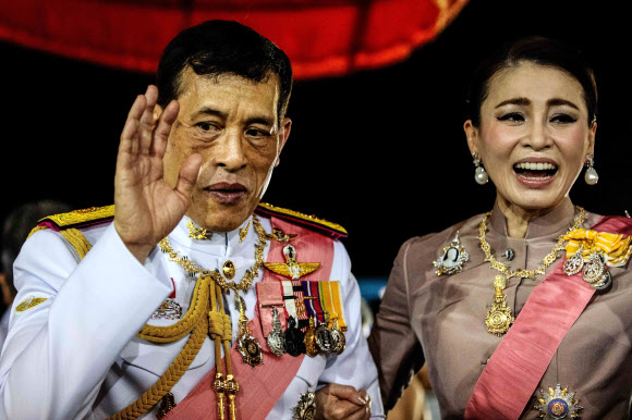 마하 와치랄롱꼰 태국 국왕과 수티다 왕비가 23일(현지시간) 방콕 왕궁에서 거행된 푸미폰 아둔야뎃 전 국왕의 서거 4주기 기념 행사에 참석해 왕실 지지자들에게 인사하고 있다. AFP 연합뉴스