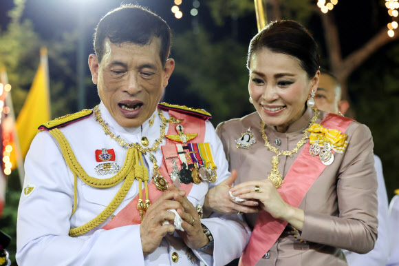 마하 와치랄롱꼰 태국 국왕과 수티다 왕비가 23일(현지시간) 방콕 왕궁에서 거행된 푸미폰 아둔야뎃 전 국왕의 서거 4주기 기념 행사에 참석해 왕실 지지자들에게 인사하고 있다. 로이터 연합뉴스