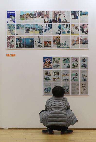 지난 16일 경기 파주출판도시에서 진행한 ‘BOOK(北) 읽는 풍경 전시회’에서 한 어린이가 북한 어린이책을 바라보고 있다.  동아일보