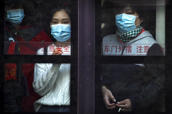중국 신장위구르 자치구 내 카스 지역에 코로나19 감염자(무증상)가 130명 이상 확인된 가운데 26일 수도 베이징 시민들이 마스크를 쓴 채 창 밖을 내다보고 있다. 2020.10.26  AP 연합뉴스