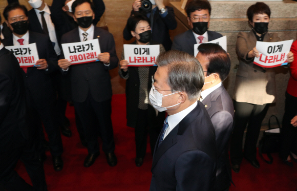 문재인 대통령이 28일 2021년도 예산안 시정연설을 위해 서울 여의도 국회 본관에 도착해 라임?옵티머스 특검요구 구호와 피켓시위를 하는 국민의 힘 의원들 앞을 지나 본회의장으로 향하고 있다.2020. 10. 28 도준석 기자 pado@seoul.co.kr