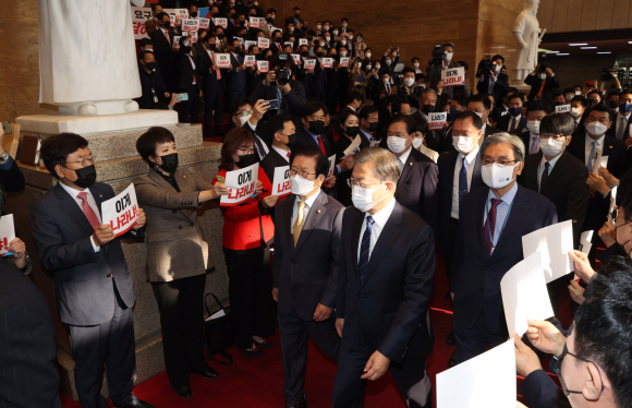 문재인 대통령이 28일 오전 2021년도 예산안 시정연설을 하기 위해 국회 본회의장으로 들어서고 있다. 문 대통령이 입장하자 국민의 힘 의원들이 라임ㆍ옵티머스 특검을 요구하는 손팻말을 들고 있다. 2020. 10. 28 도준석 기자pado@seoul.co.kr