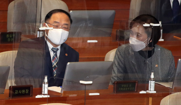 홍남기 경제부총리 겸 기획재정부 장관과 유은혜 사회부총리 겸 교육부 장관이 28일 오전 서울 여의도 국회에서 문재인 대통령 2021년 예산안에 대한 시정연설에 앞서 청와대 경호원의 주호영 원내대표 검문에 항의하는 야당의원들을 바라보고 있다.